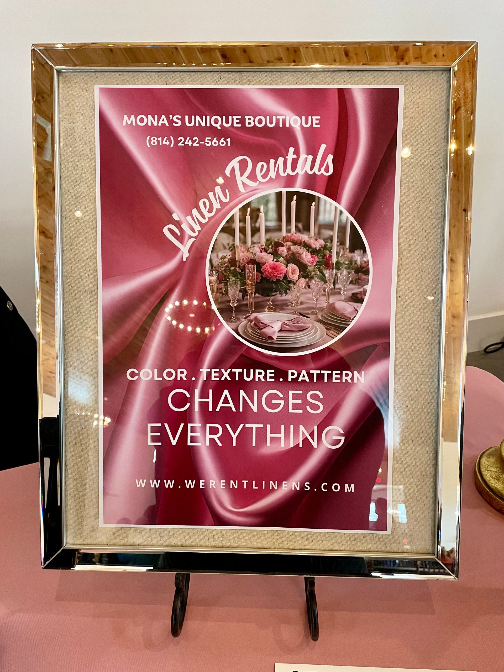 Pink gold-framed sign reading “Color, texture, pattern changes everything” on a stand.