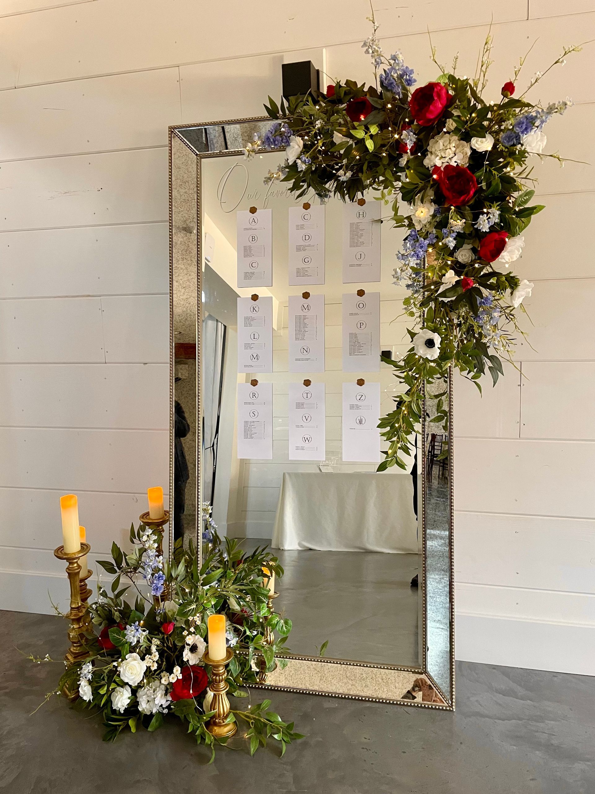 Decorated standing mirror with flowers, candles, and cards, likely a memorial or tribute display