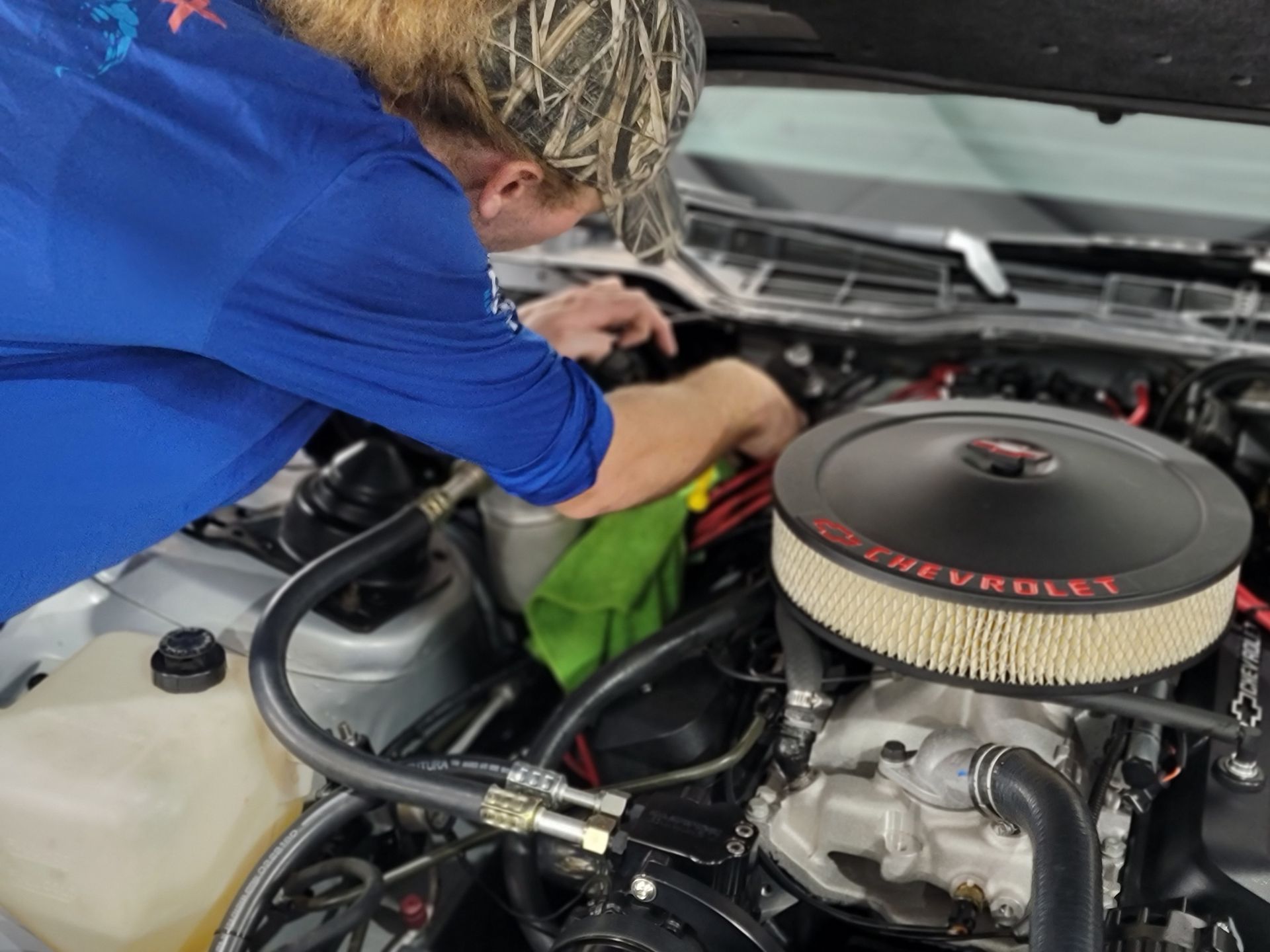 A man is working on the engine of a car.