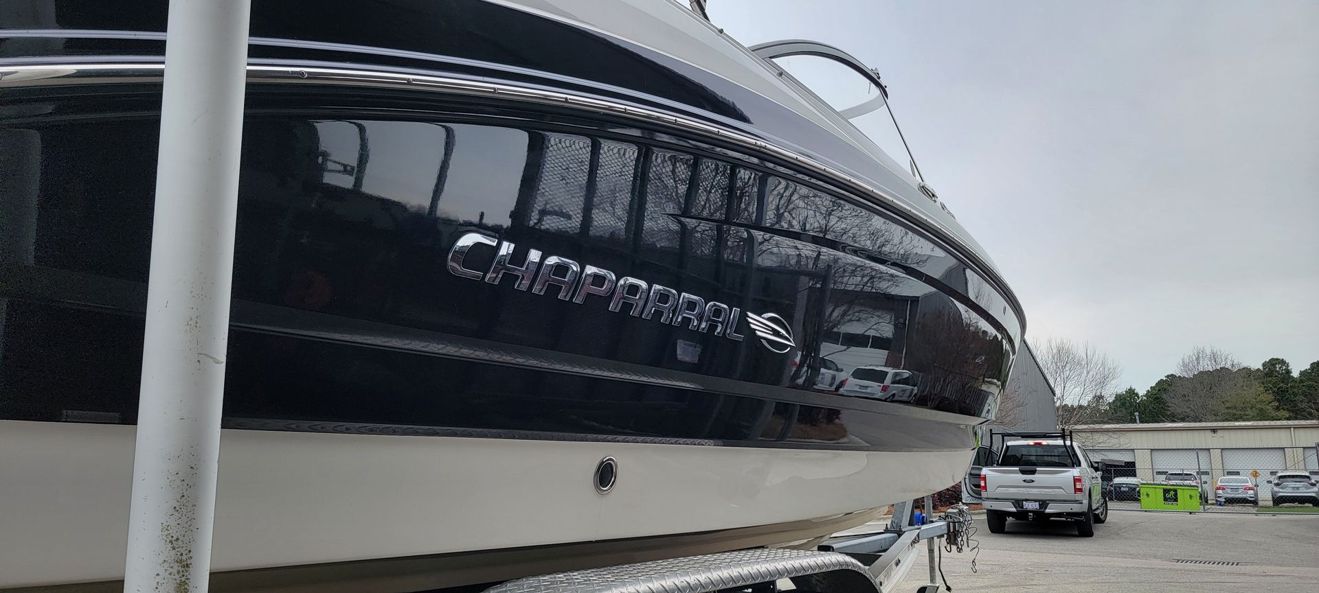 A boat is sitting on a trailer in a parking lot.