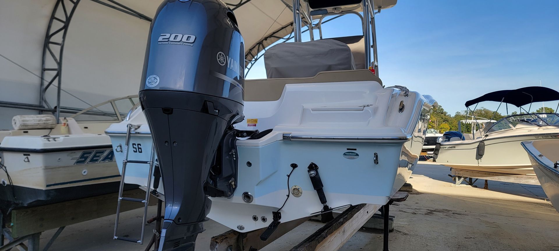 A boat with a yamaha outboard motor is parked in a warehouse.