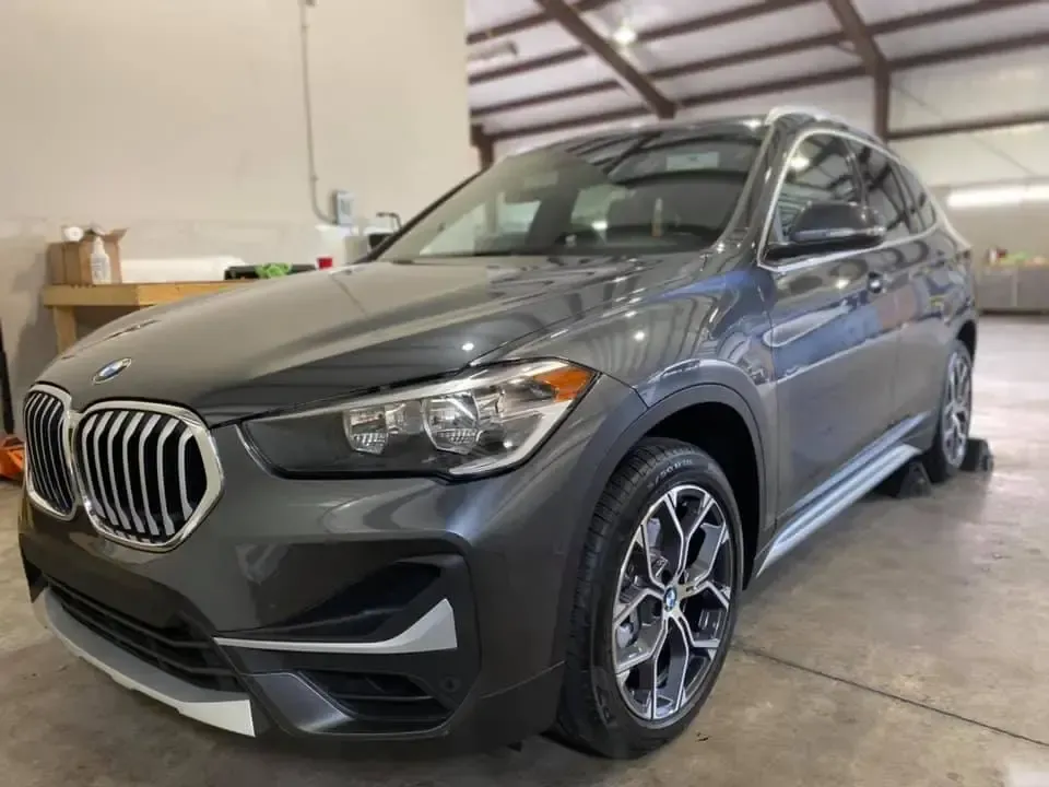 A gray bmw x1 is parked in a garage.