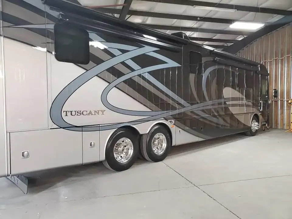 A large rv is parked in a garage.