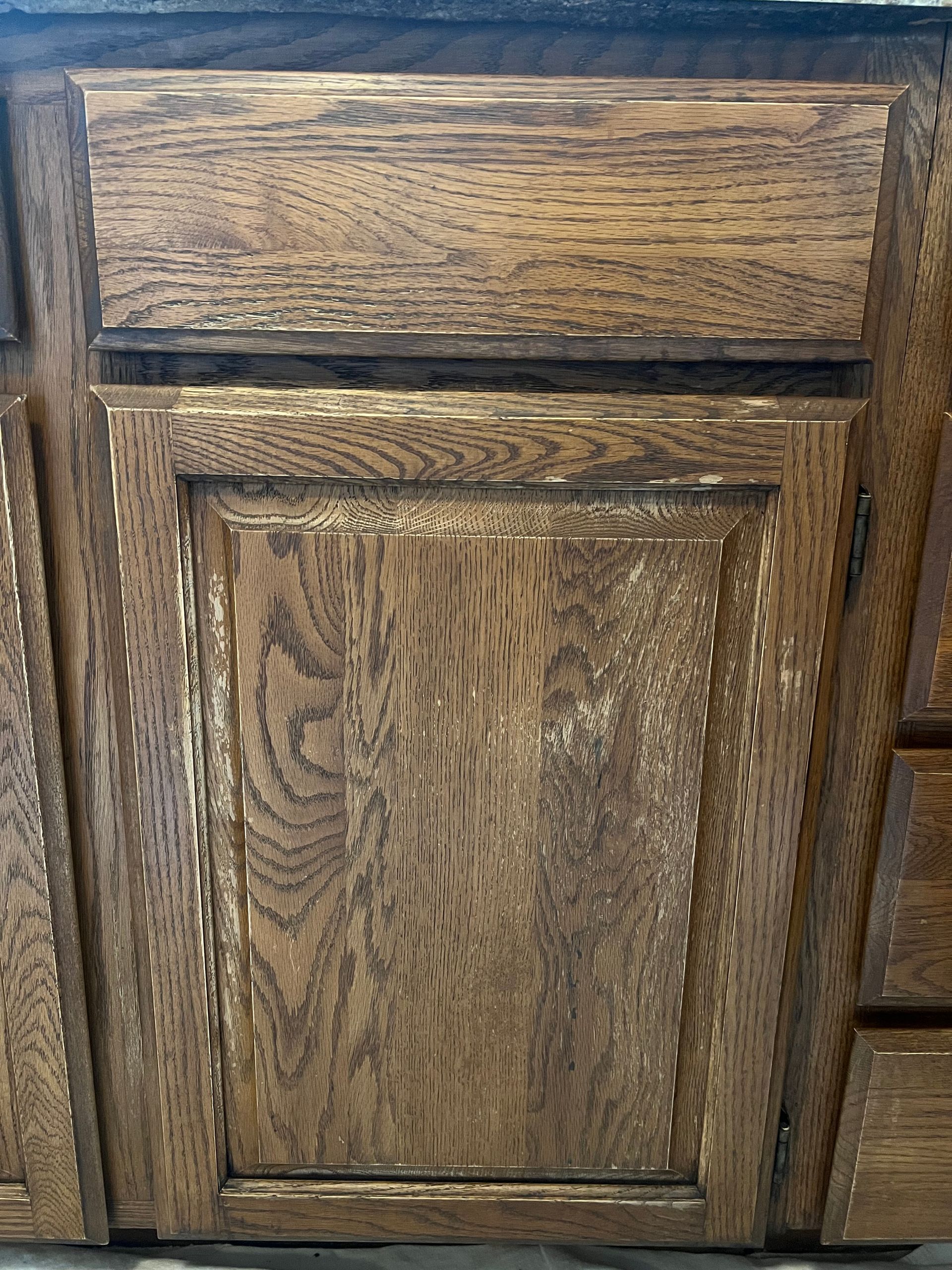 Wooden kitchen cabinet with a stained, textured surface.