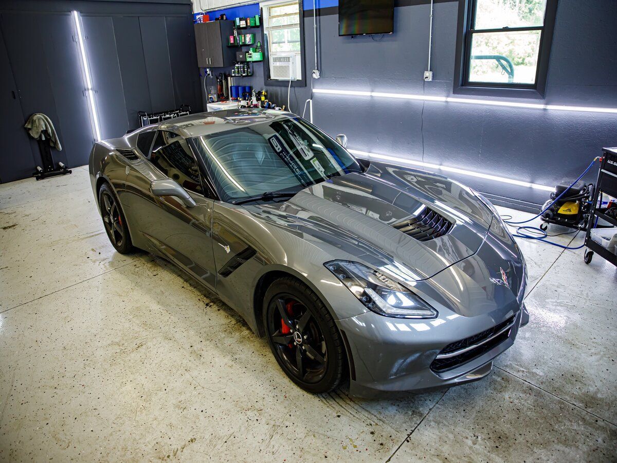 Gray Chevrolet Corvette sports car inside a garage.