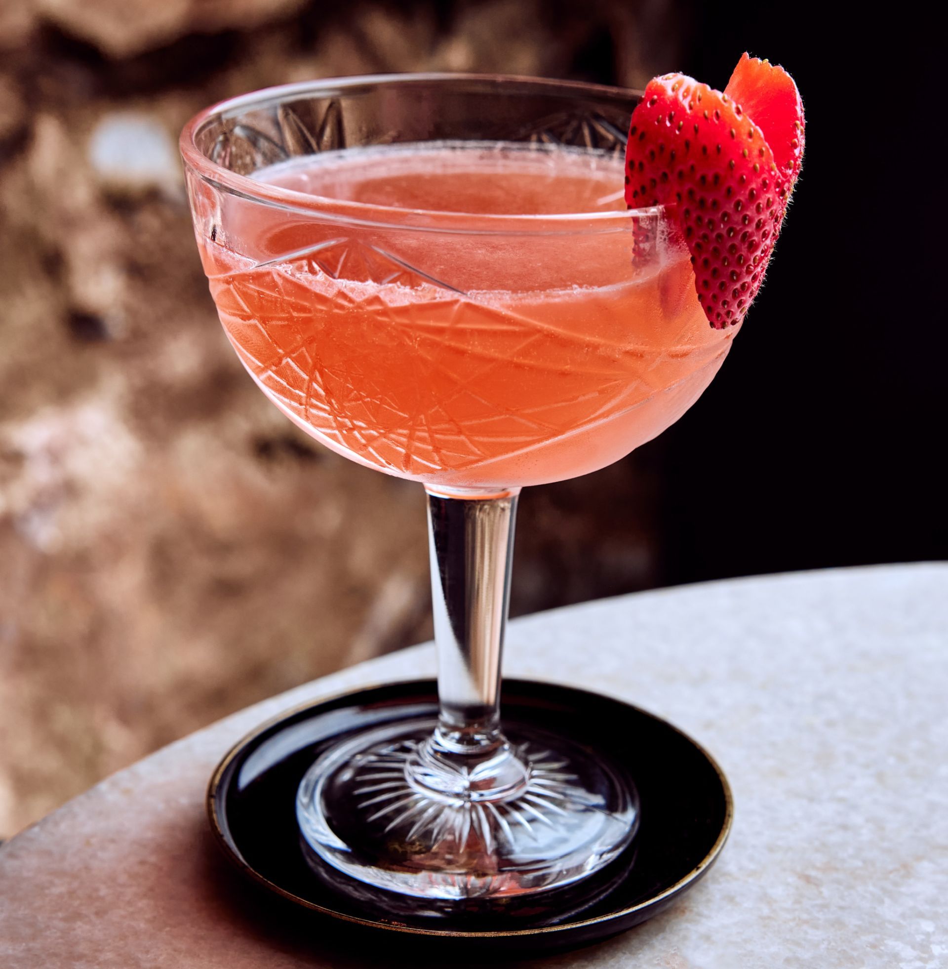 Signature cocktail called the black tie with whiskey and strawberries
