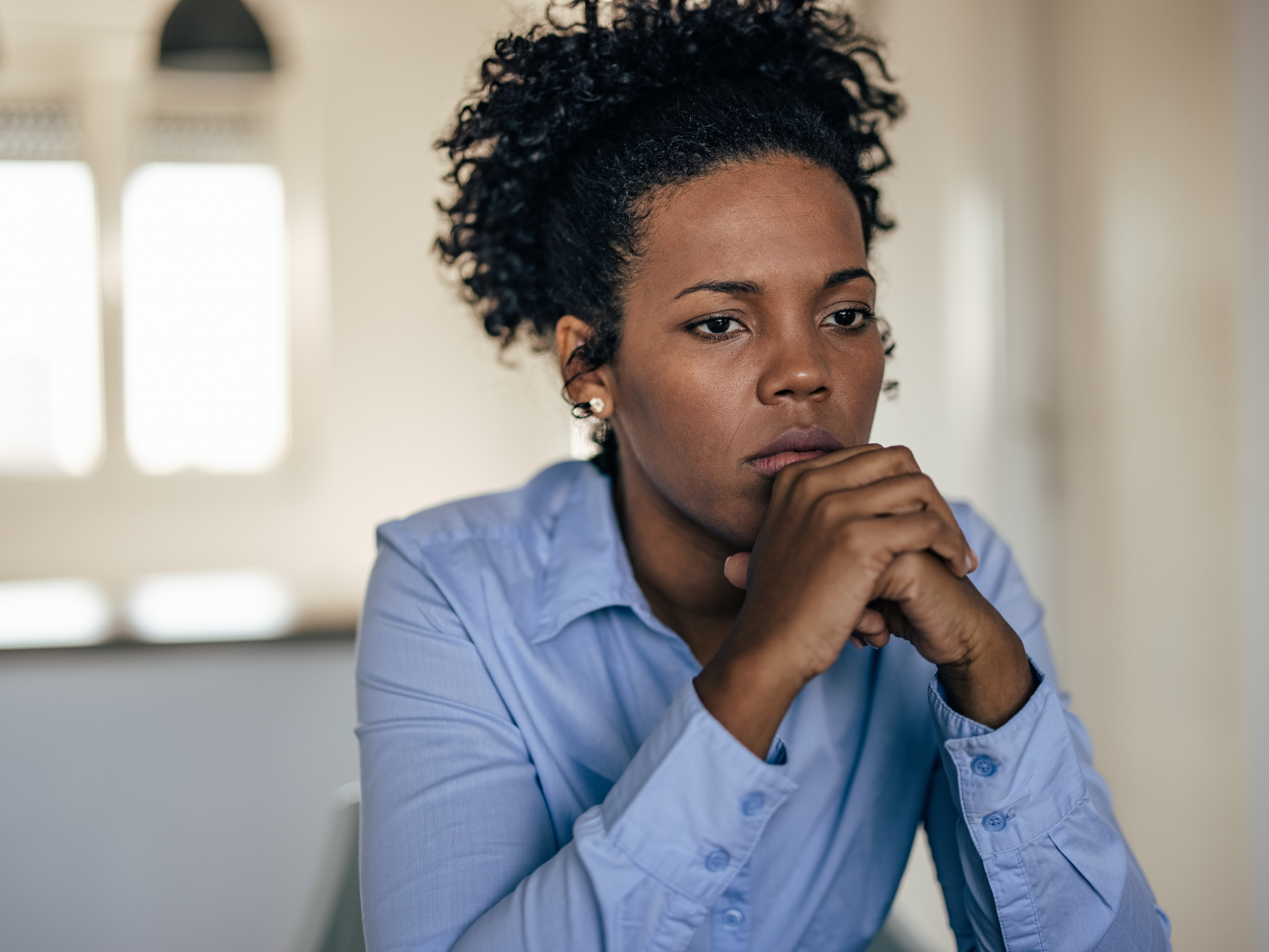 Stressed coworkers at a desk, one holding her head, with headline about Sunday anxiety and workplace worries