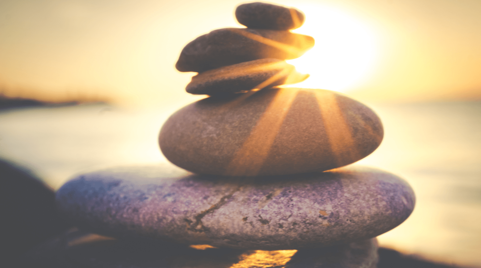 A pile of rocks stacked on top of each other with the sun shining through them.