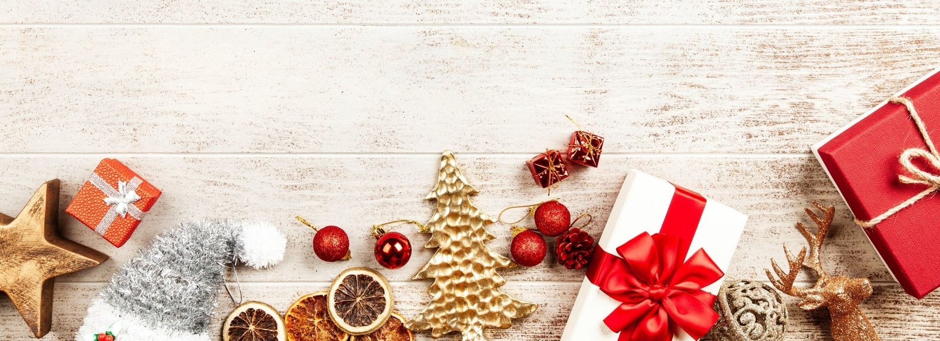 A wooden table topped with christmas decorations and gifts.