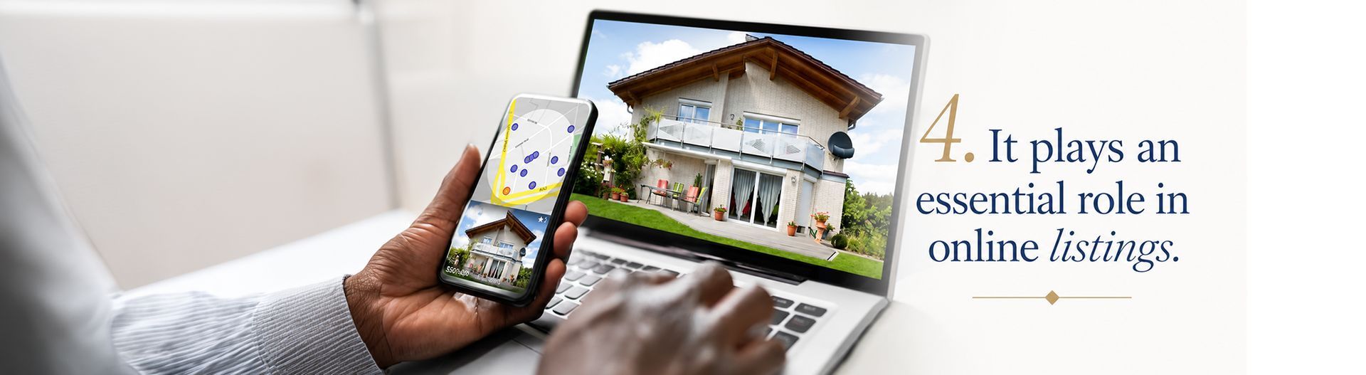 Hand holding a smartphone showing a house listing beside a laptop with a home sale page.