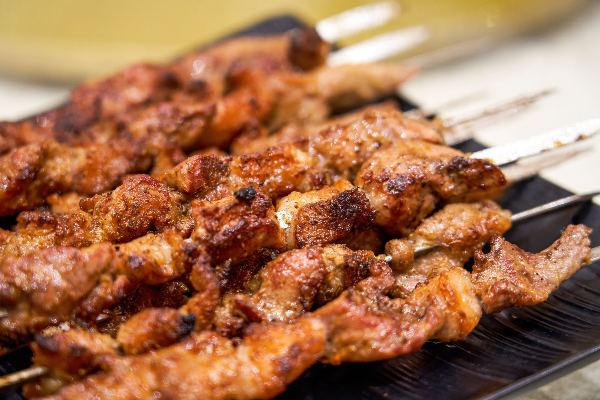 Primo piano di un piatto di carne infilzato su uno spiedino su un tavolo.
