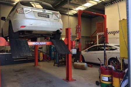 Car is Sitting on a Lift in a Garage — Oaks Automotive Pty Ltd in Oak Flats, NSW