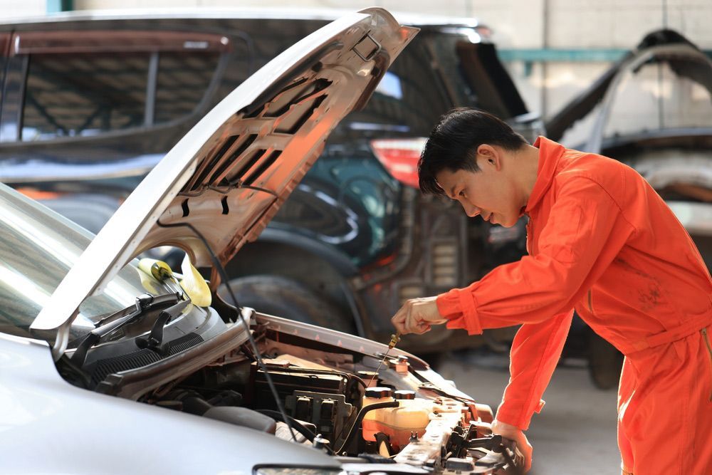 Man is Working on the Engine of a Car in a Garage — Oaks Automotive Pty Ltd in Oak Flats, NSW