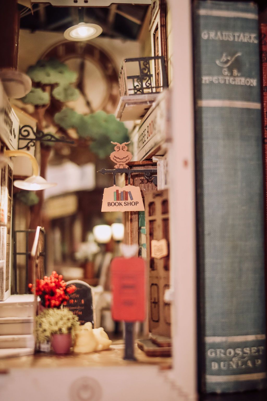 Miniature street scene with a bookstore sign next to a large book.