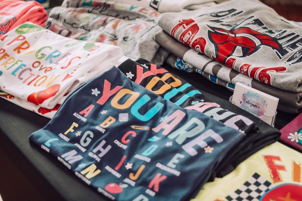 T-shirts with colorful designs, including the alphabet, 
