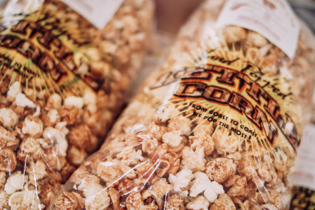 Bags of caramel corn with yellow and brown labels, in clear plastic.