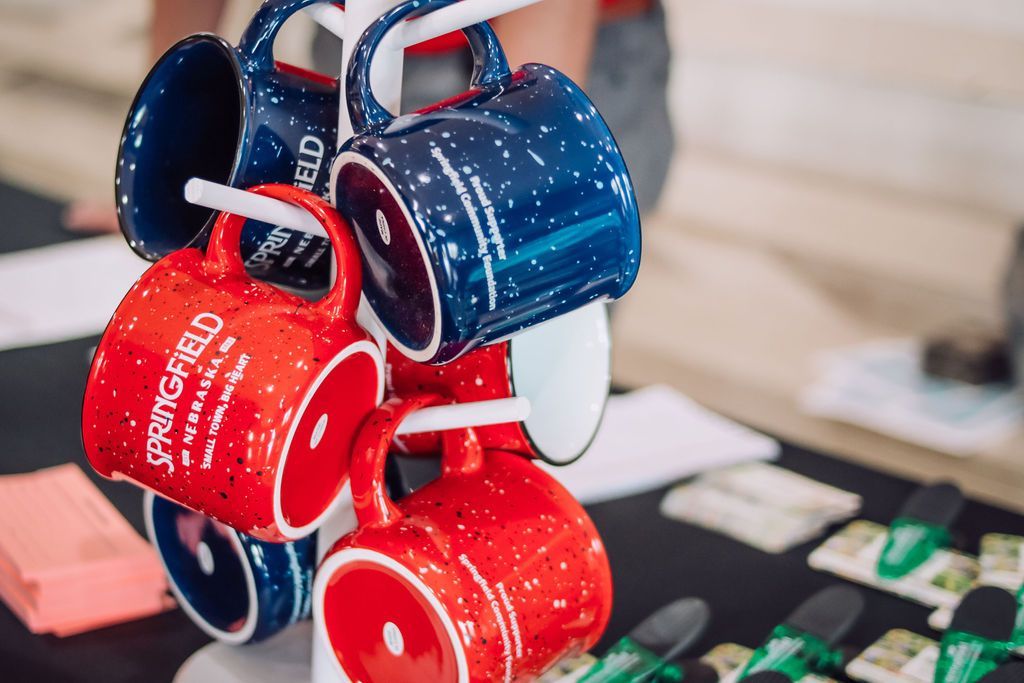Mugs on a display rack; red and blue speckled designs, 
