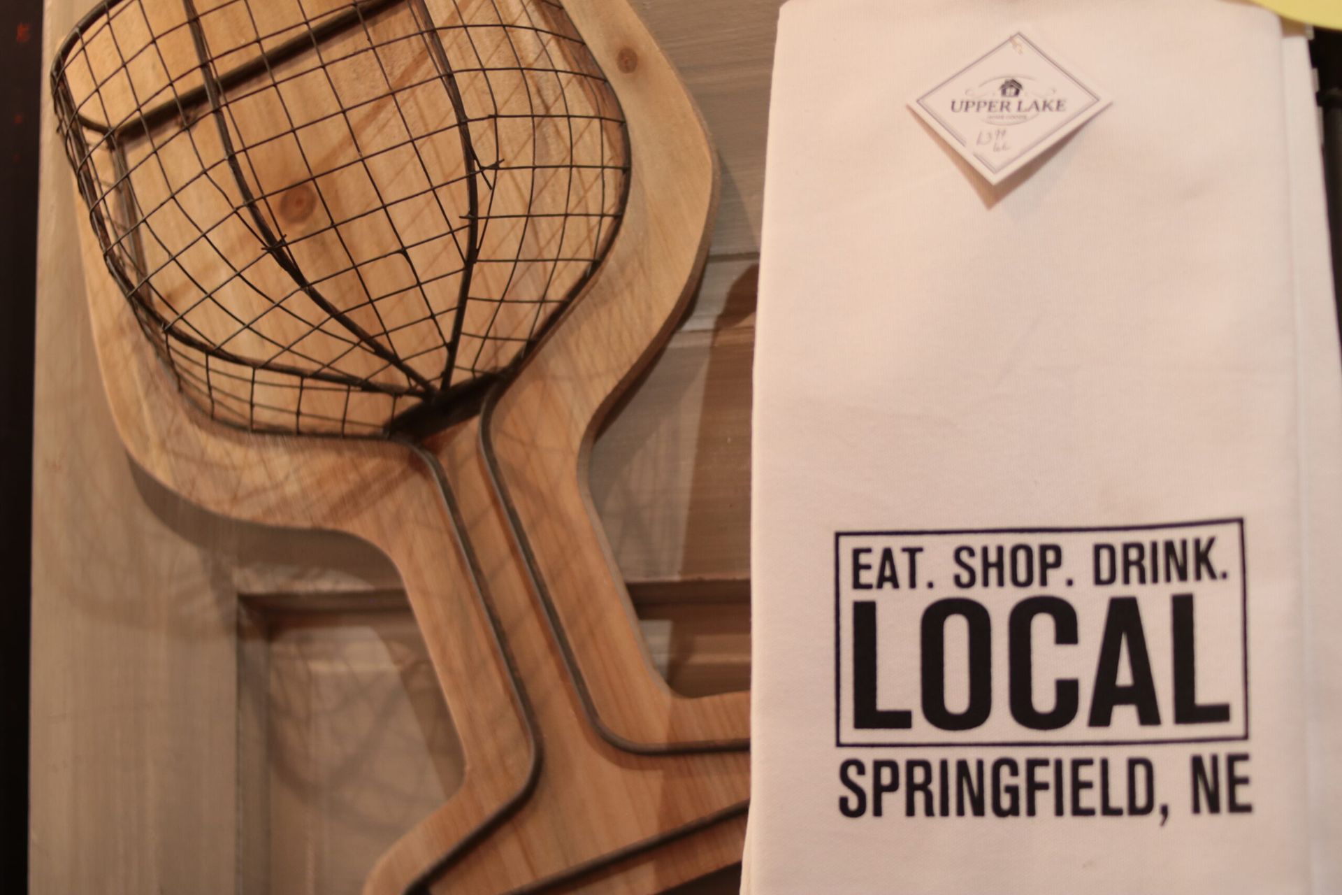 Wooden pizza peel with wire basket, and white towel with 