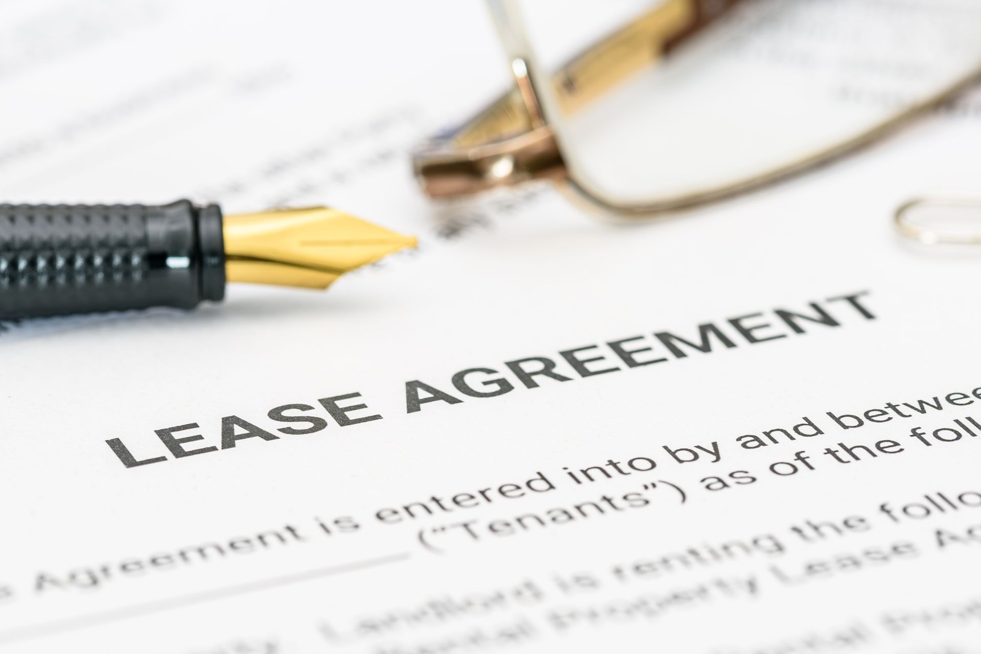 Lease agreement document with pen and eyeglasses on a desk