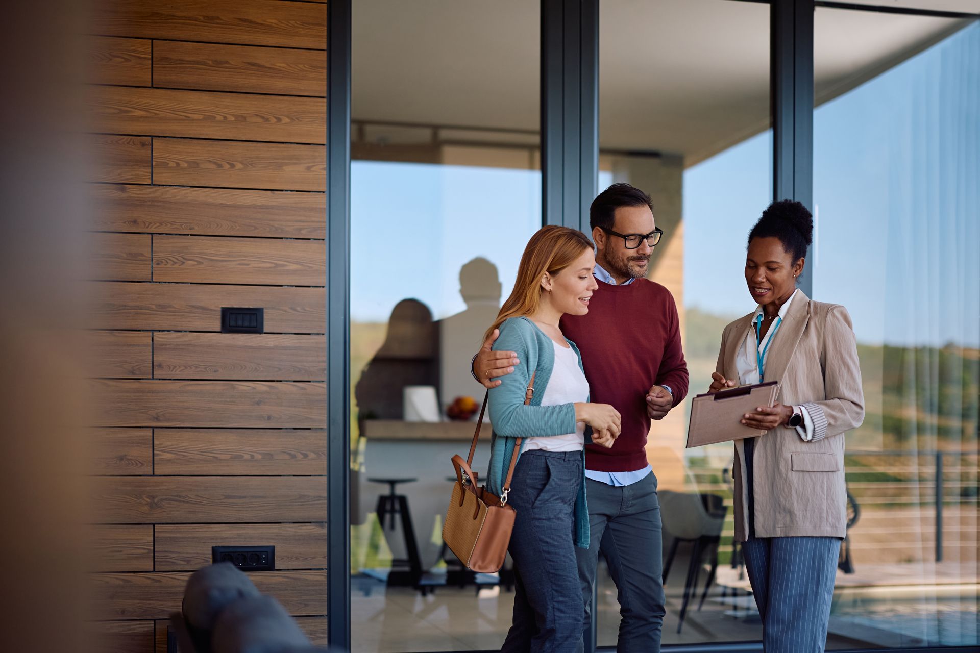 Three coworkers discussing a document outside a modern office building