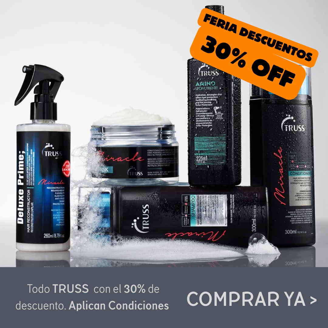 Perro y gato descansando en un sofá gris. El perro es canela, el gato es blanco y negro, ambos con collar.