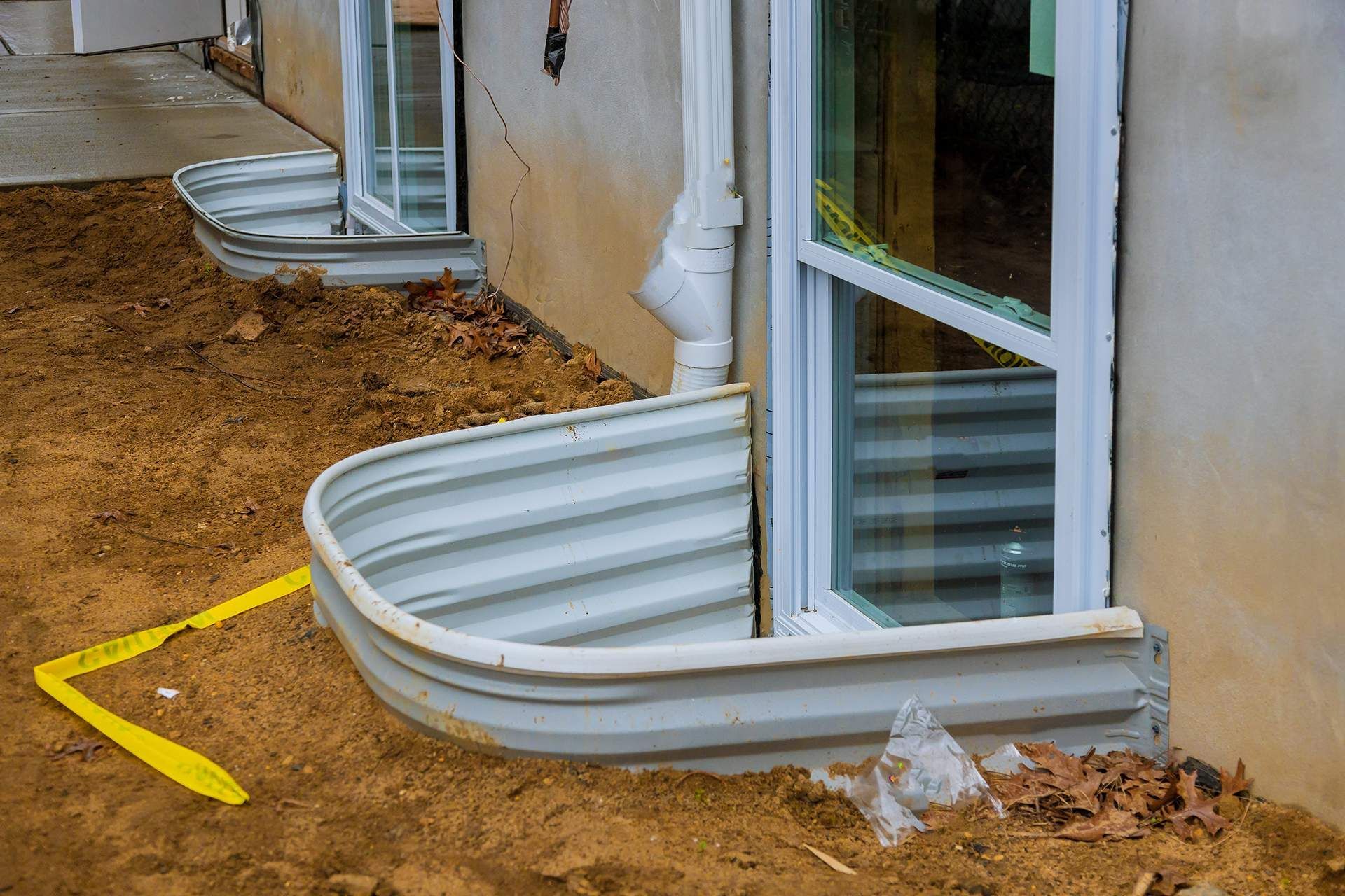 A row of window wells on the side of a house.