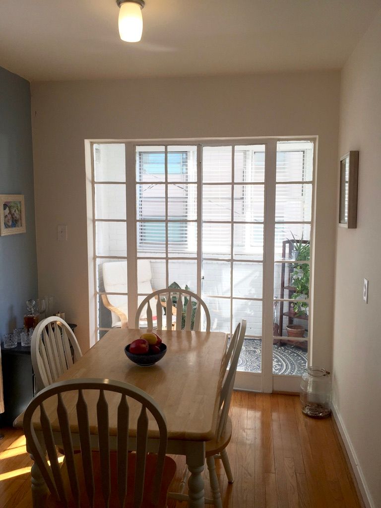 A dining room with a table and chairs and a bowl of fruit on the table.