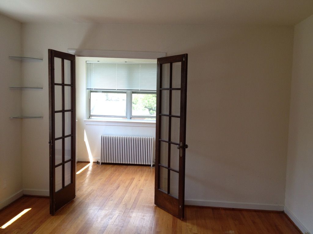 An empty room with hardwood floors and french doors