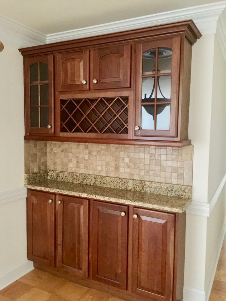 A kitchen with wooden cabinets and a wine rack