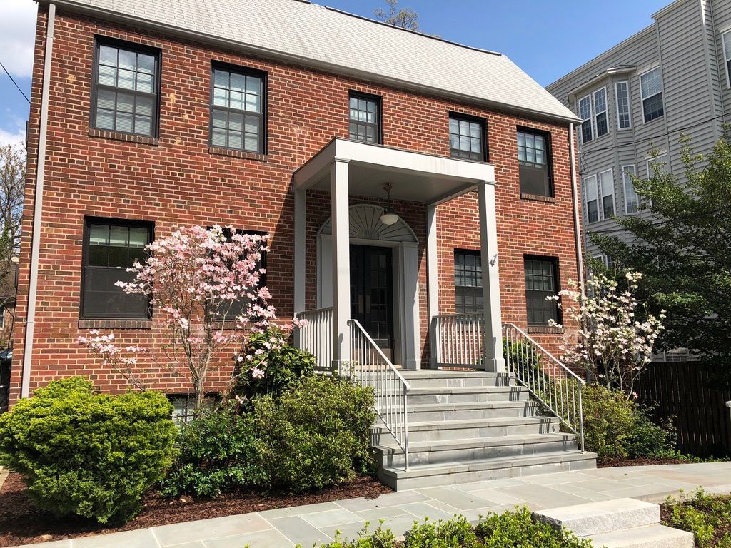 A large brick house with a porch and stairs