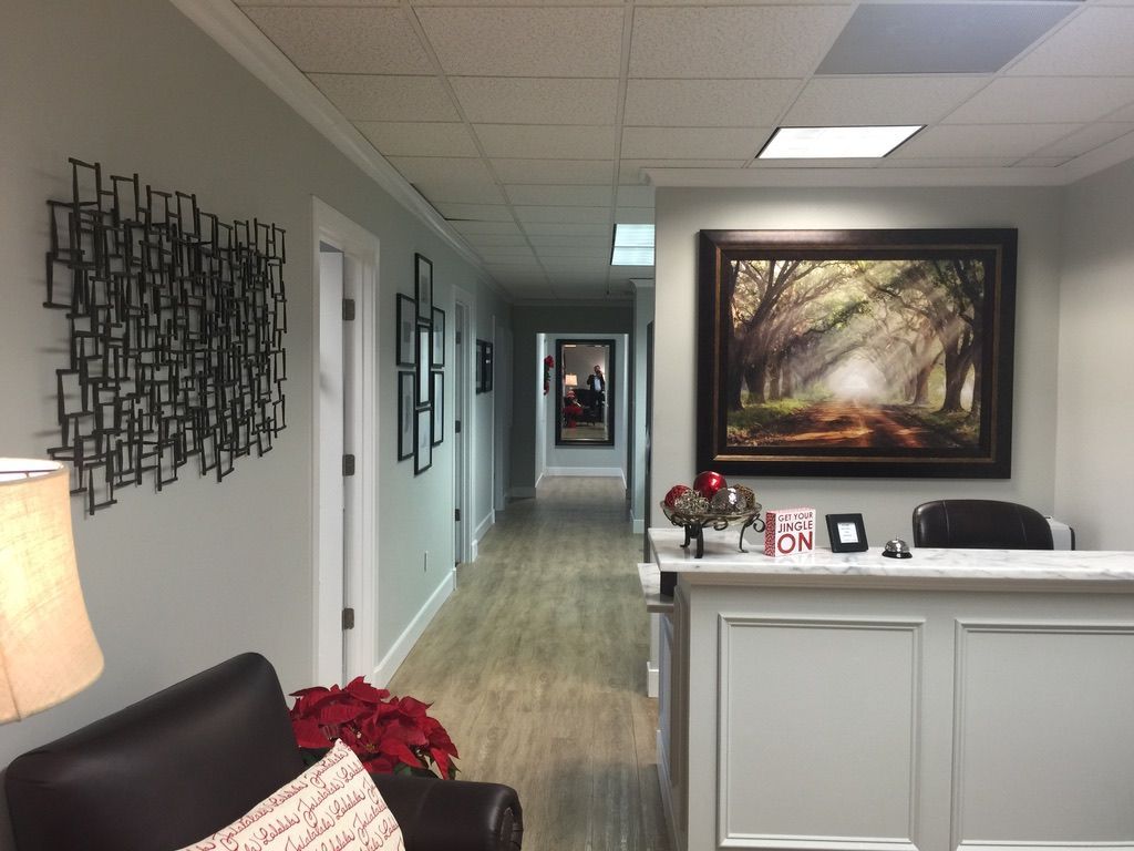 A long hallway with a couch and a picture on the wall.