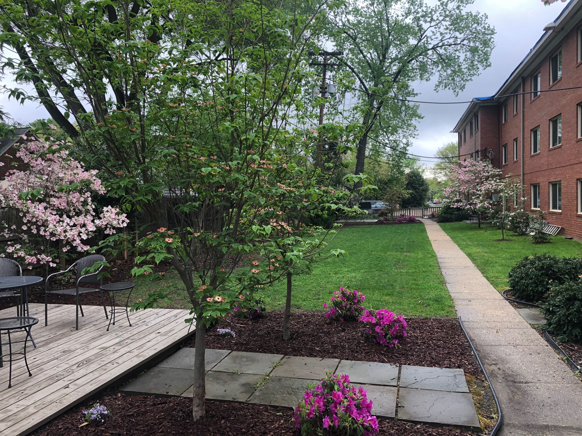 A brick building with a lush green lawn and a walkway leading to it.