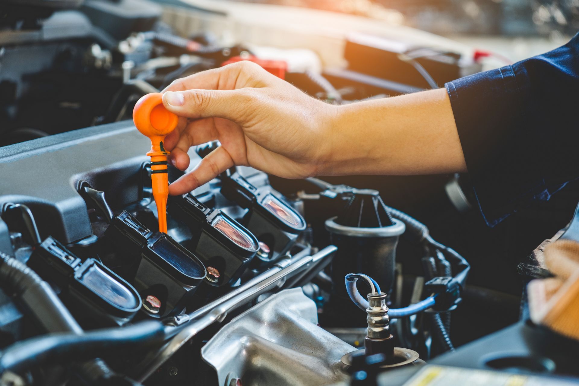 A person is checking the oil level of a car engine.