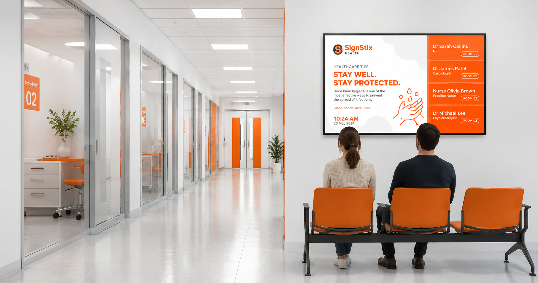 Two people sit in an orange-and-white office lobby, facing a large wall display.