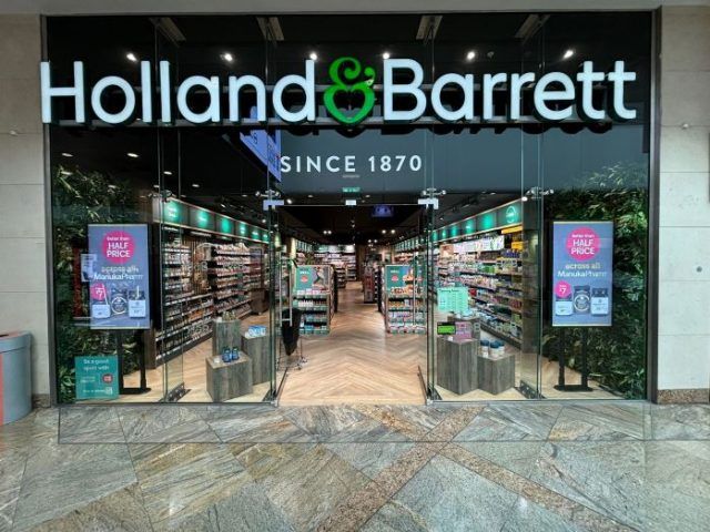 Holland & Barrett storefront with open entrance and illuminated signs in a shopping mall