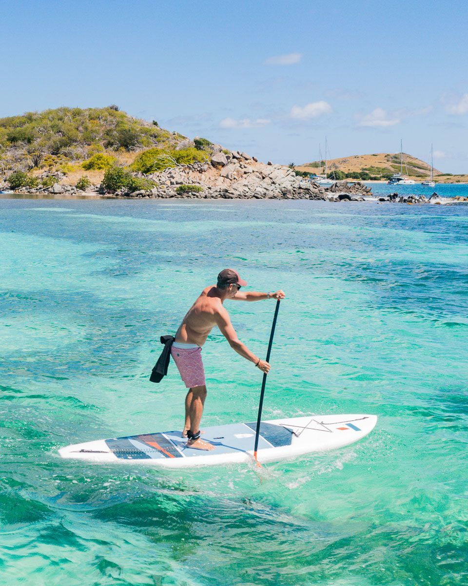 A man is riding a paddle board in Saint-Martin.