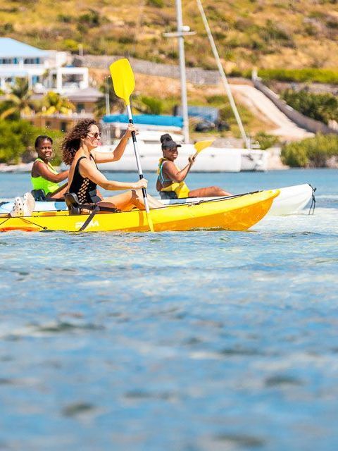A group of people are paddling kayaks in the water.
