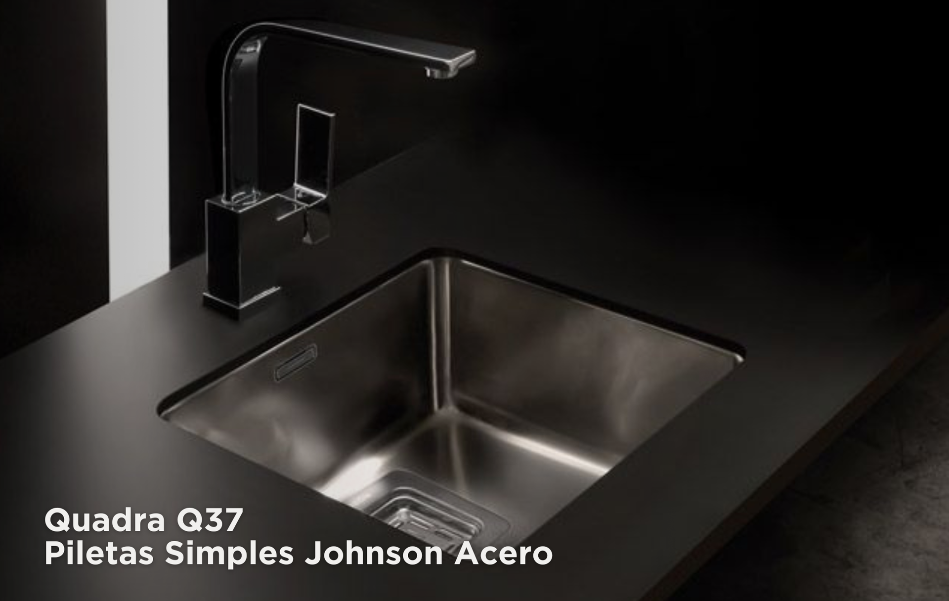 Fregadero de cocina negro con grifo y encimera cromados, etiquetado como “Quadra Q37 Piletas Simples Johnson Acero”.