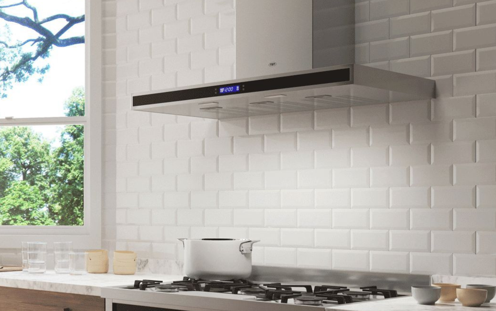 Cocina moderna con salpicadero de azulejos blancos, cocina de gas y campana extractora negra junto a una ventana.