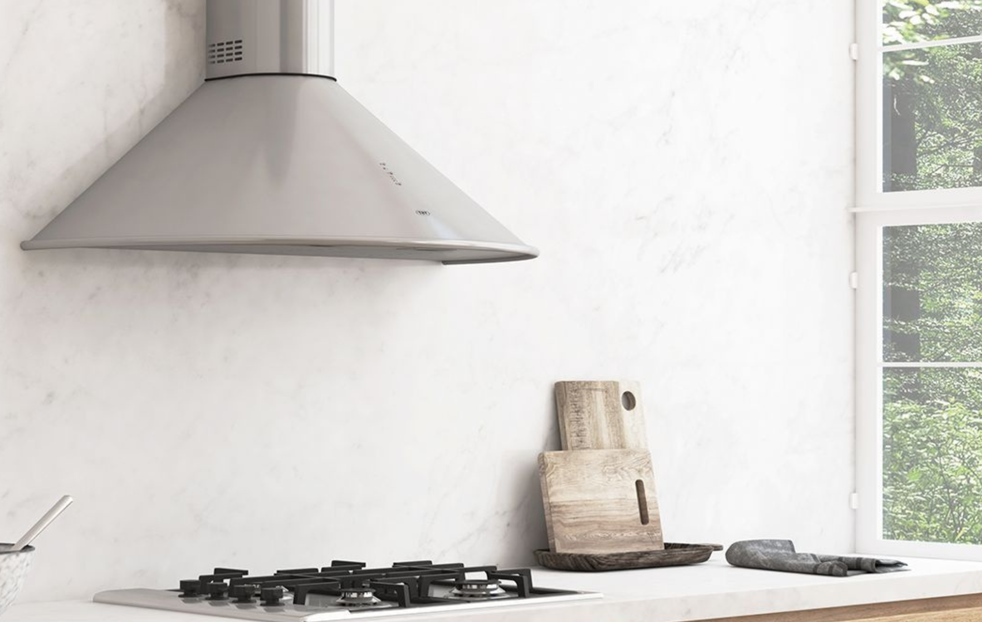 Cocina moderna con campana extractora de acero inoxidable, estufa de gas, encimeras blancas y ventana.