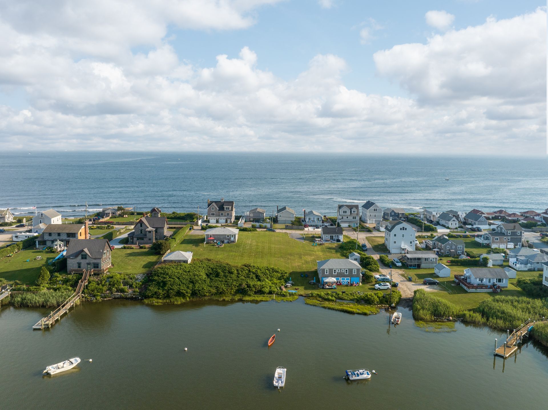 An aerial view of a small town next to the ocean with boats in the water.
