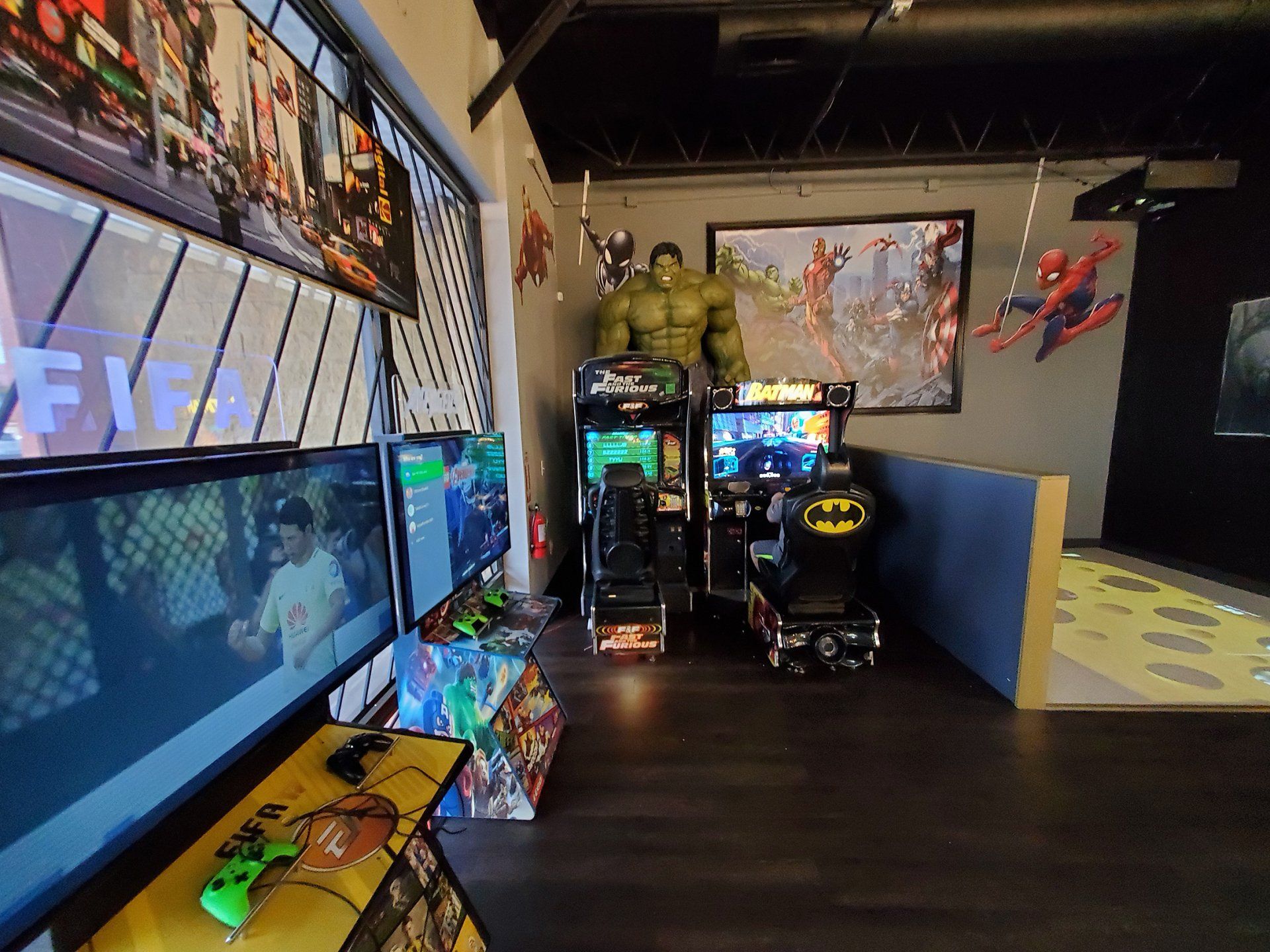 Arcade room with racing game cabinets, neon lights, and colorful wall art