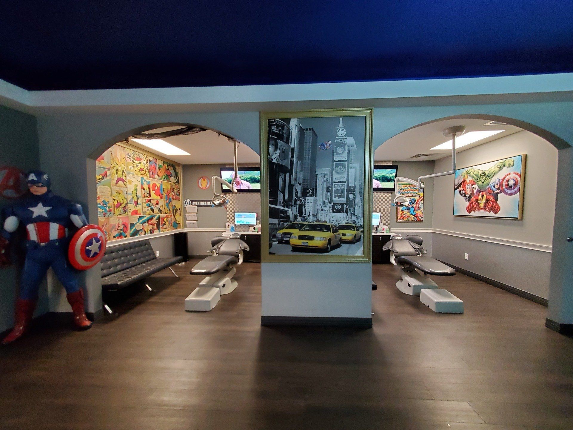 Captain America statue in a comic-themed display room with benches and framed city artwork