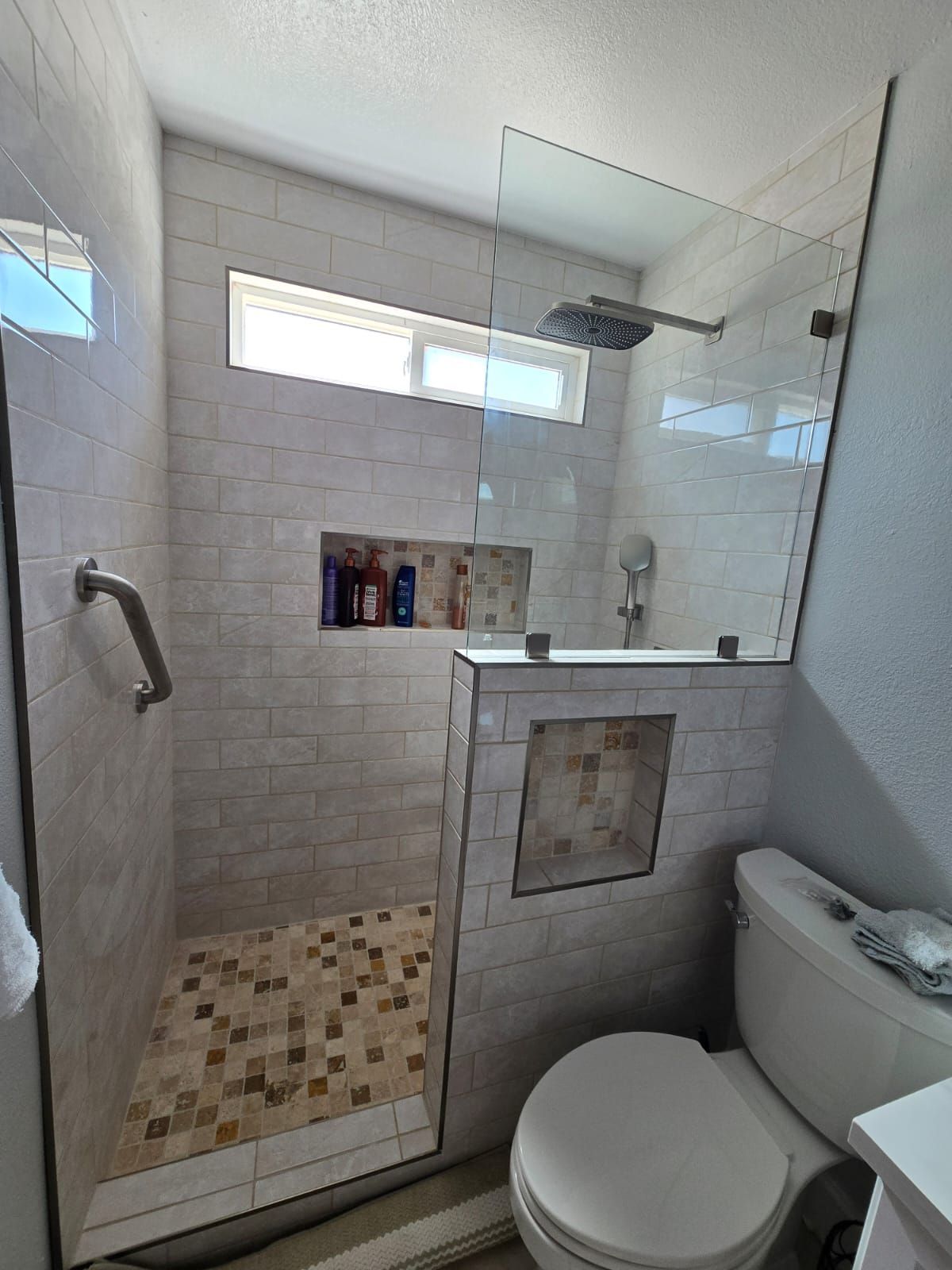 A bathroom with a walk in shower and a toilet.