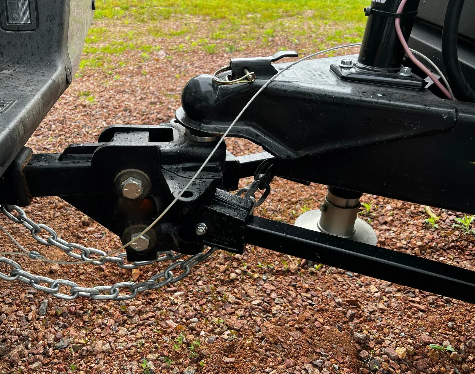 A trailer is attached to a truck with chains.