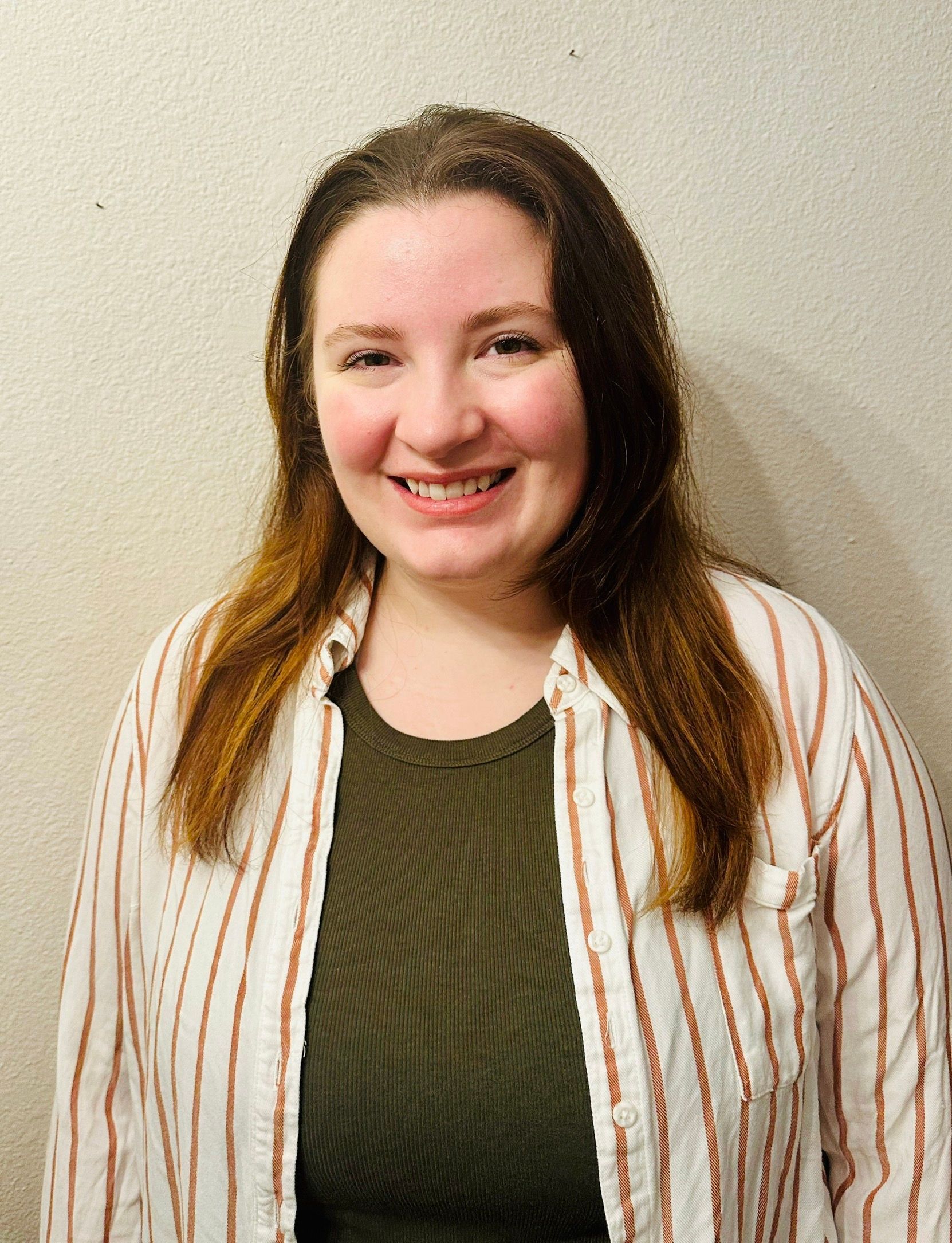 A woman in a striped shirt is smiling for the camera.