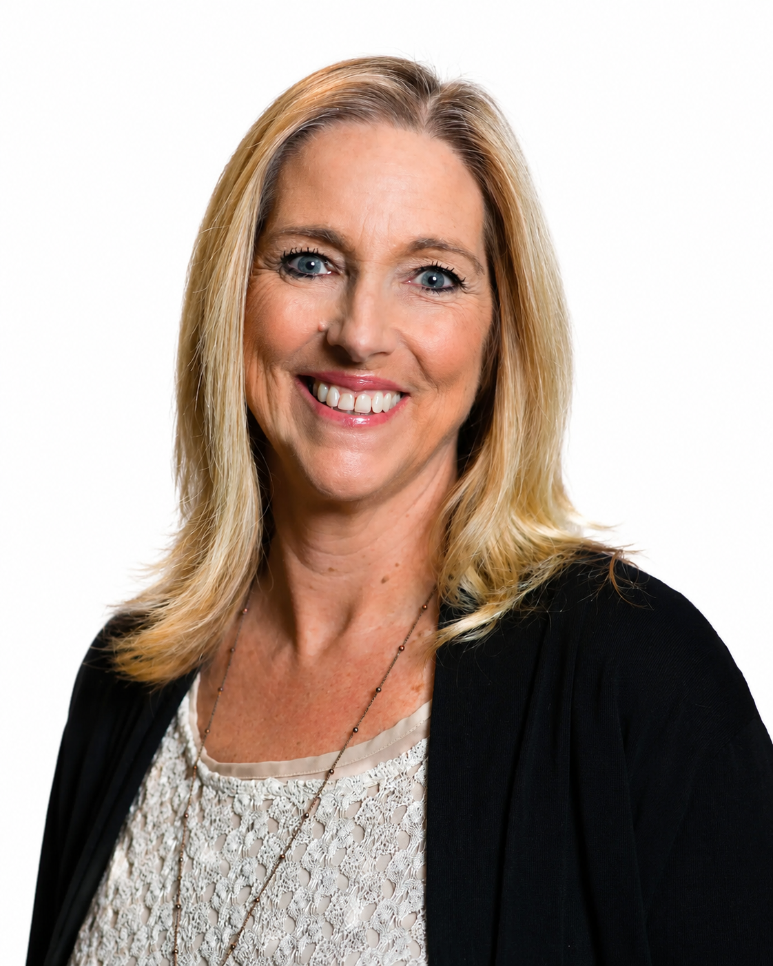 A woman wearing a black jacket and a white shirt is smiling for the camera.