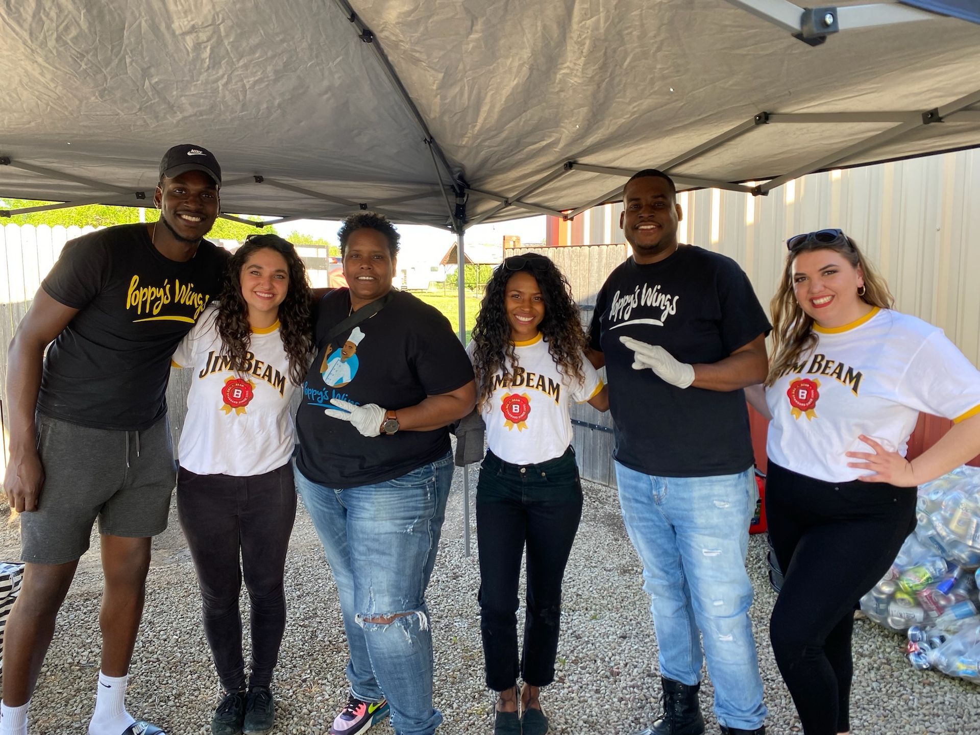 A group of people are posing for a picture under a tent.