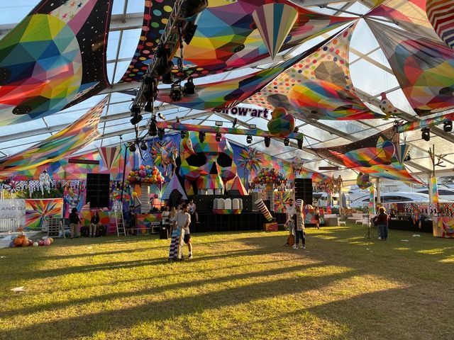 A large tent with a lot of colorful decorations hanging from the ceiling.