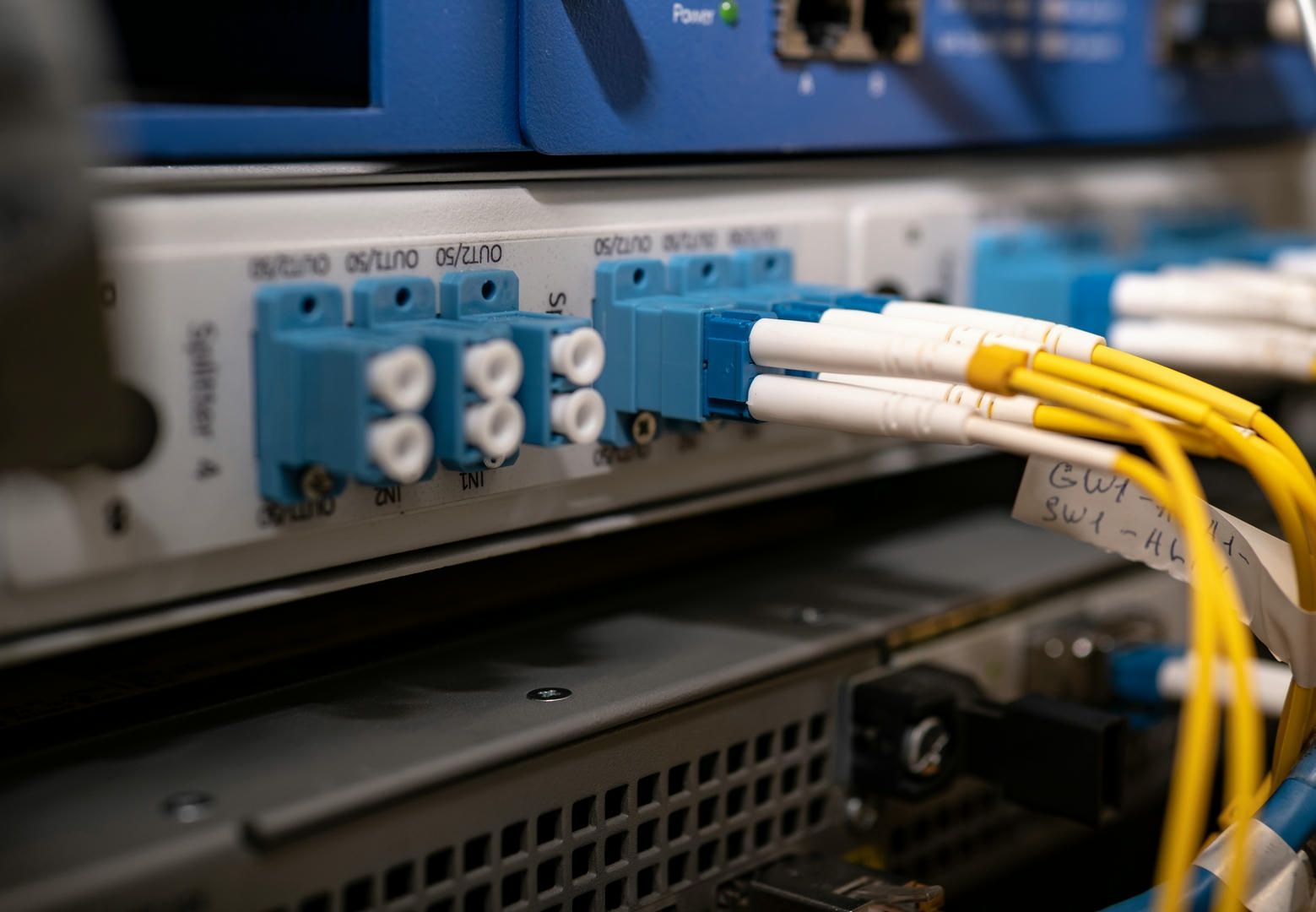 A bunch of wires are connected to a server in a server room.